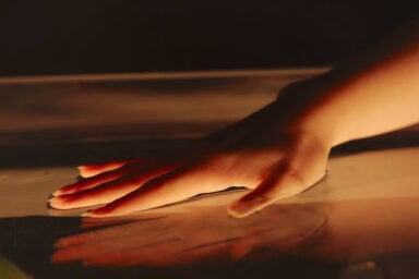 A hand gently touching the surface of water, highlighting the gentle and supportive approach of humanistic therapy.