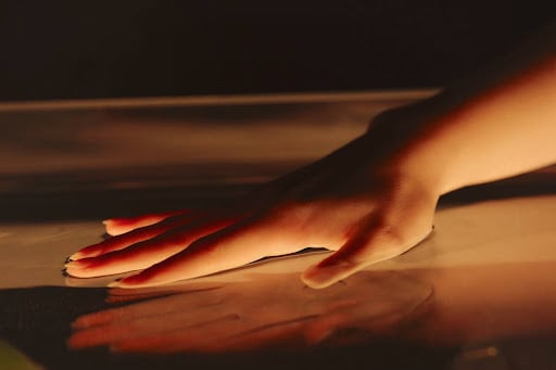 A hand gently touching the surface of water, highlighting the gentle and supportive approach of humanistic therapy.