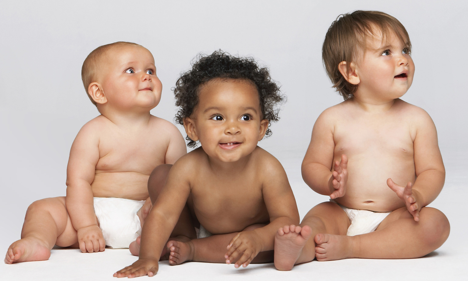 Three animated, diaper-wearing infants sit together against seamless background