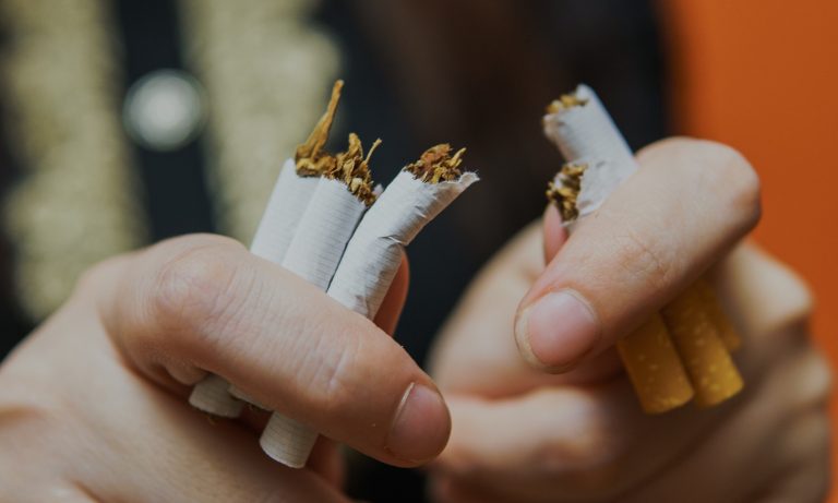 Close-up of woman's hands, breaking cigarette in half