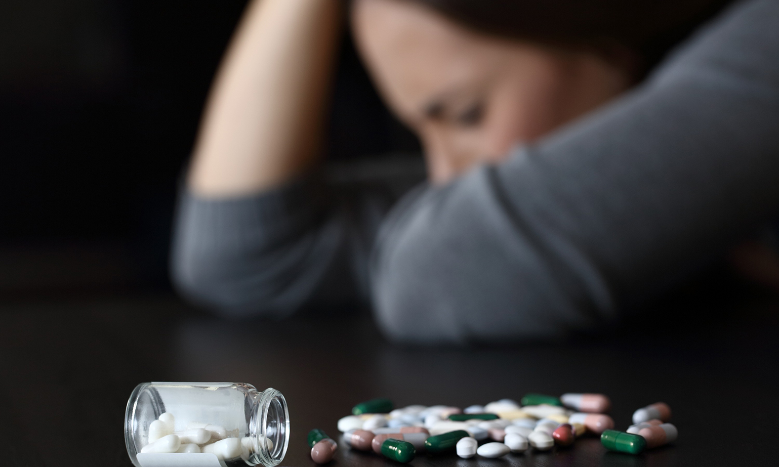 depressed woman beside a lot of pills
