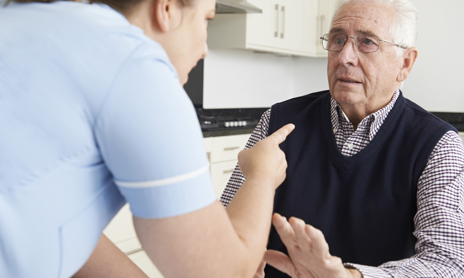 Old man being berated by care worker in his home