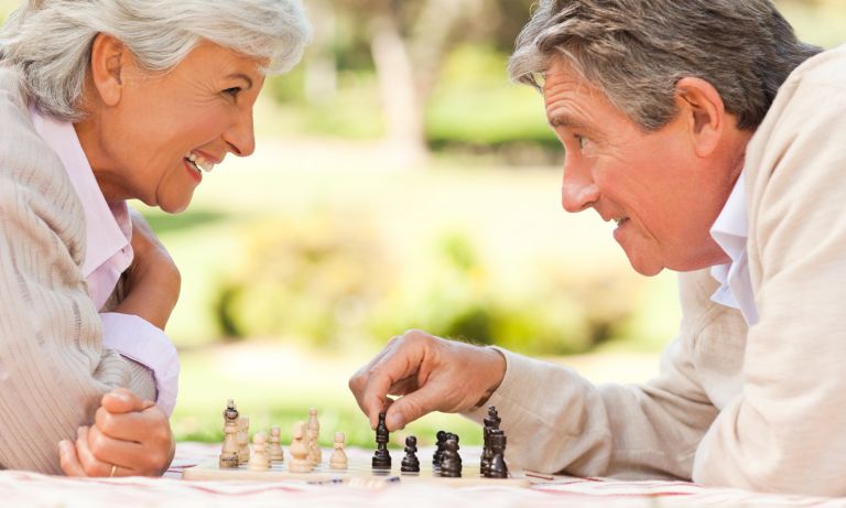 older couple playing chess outdoors 768