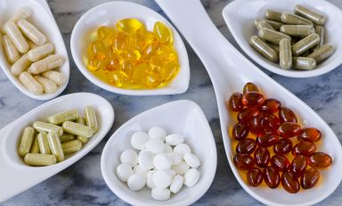 Pills, capsules, and geltabs in various dishes on a table