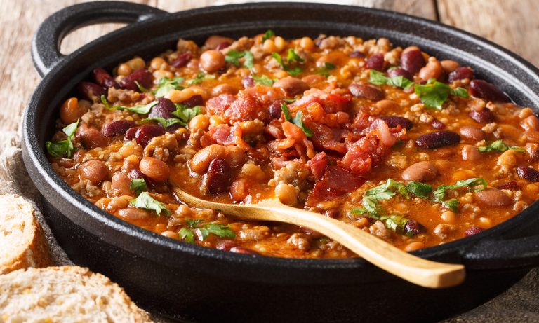 Stew in open pot, beef, beans, serving spoon
