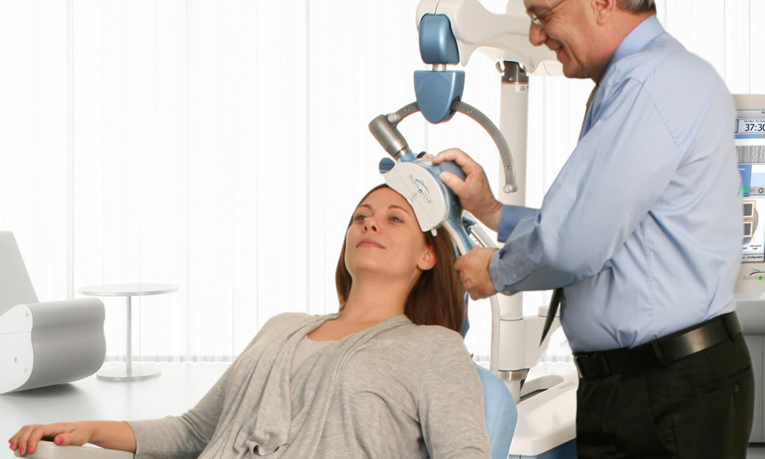 Woman in medical procedure room chair, being prepped for transcranial magnetic stimulation treatment