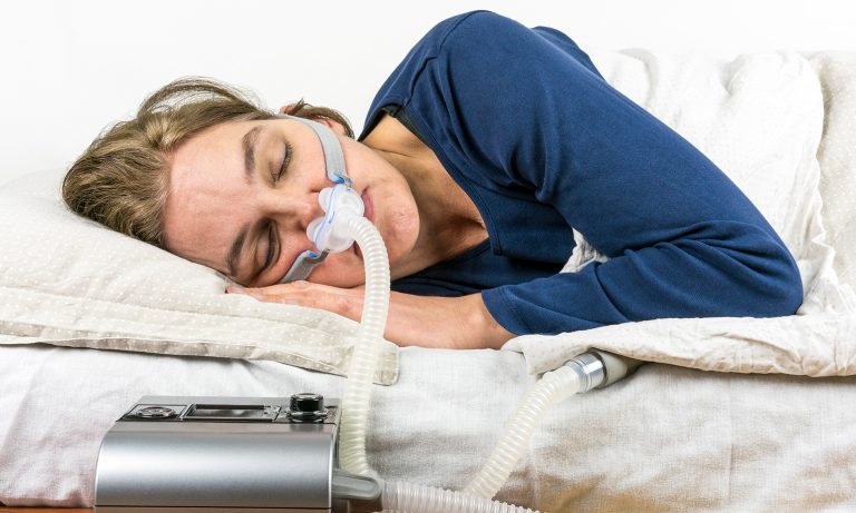 Woman sleeping on her side with CPAP machine