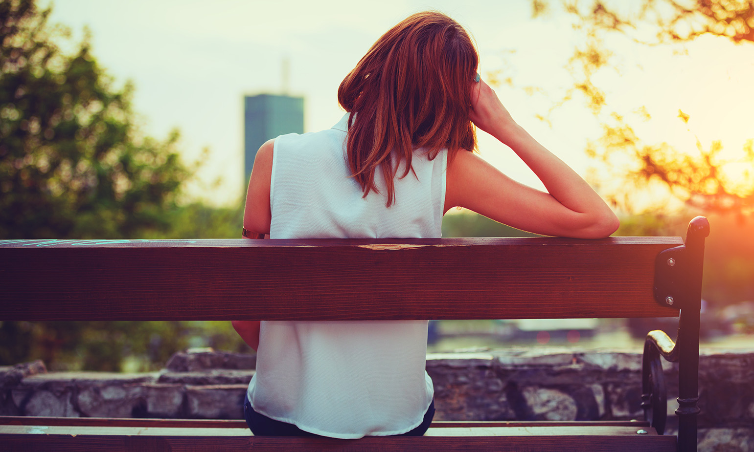 View from behind of woman sitting on park bench