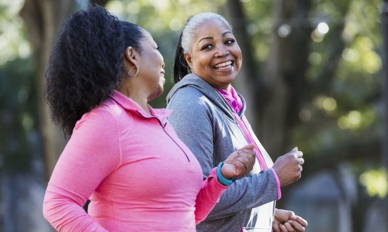 Women walking for exercise in park, smiling