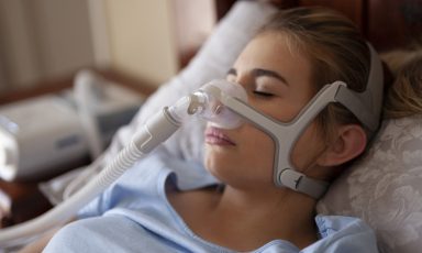 CPAP for sleep apnea on woman in bedroom
