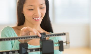 Young woman smiling while adjusting beam weight scale